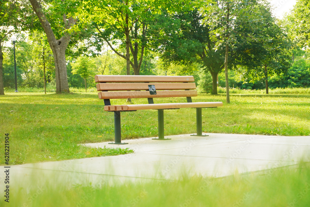 Wooden bench in the park, Warm evening in summer park, empty bench for rest. Wooden bench in the park, Warm evening in summer park, empty bench for rest.