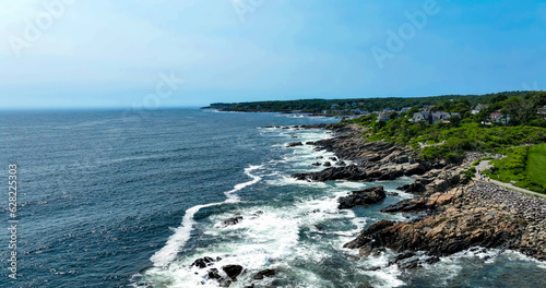 Aerial view of waves crashing over rocks near the Marginal Way running path in Ogunquit, Maine taken over the ocean.