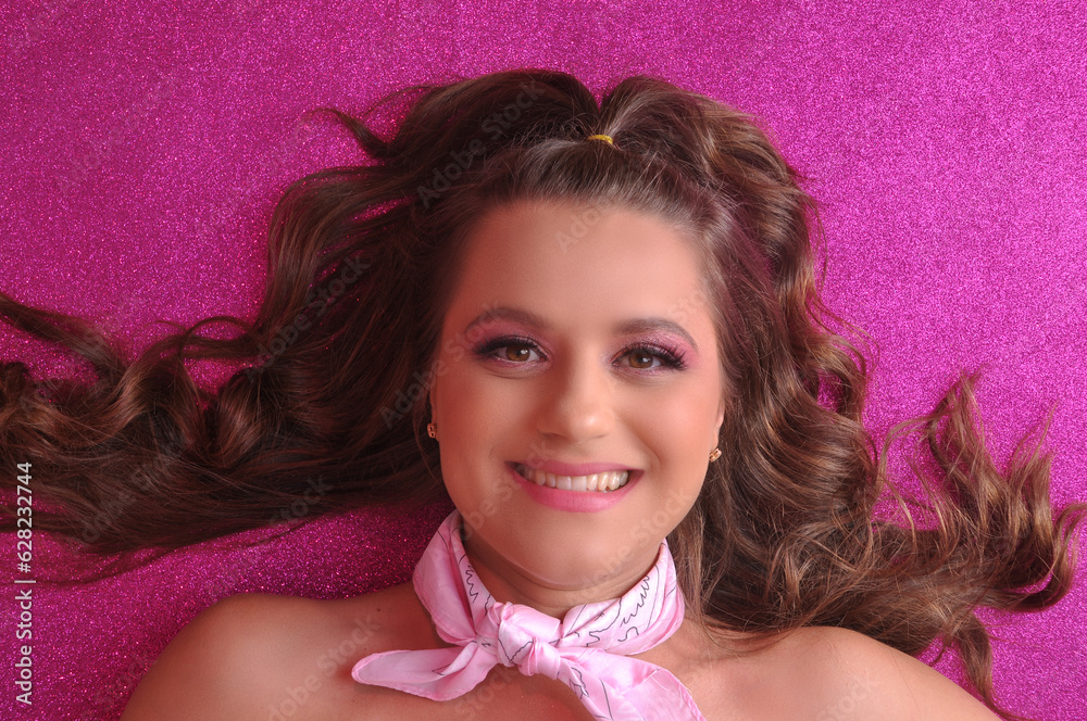 bela jovem com maquiagem profissional rosa em fundo rosa com brilho, expressão feliz e sorridente bela jovem com maquiagem profissional rosa em fundo rosa com brilho, expressão feliz e sorridente