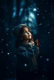 kleines Mädchen im Winter schaut den Schneeflocken zu