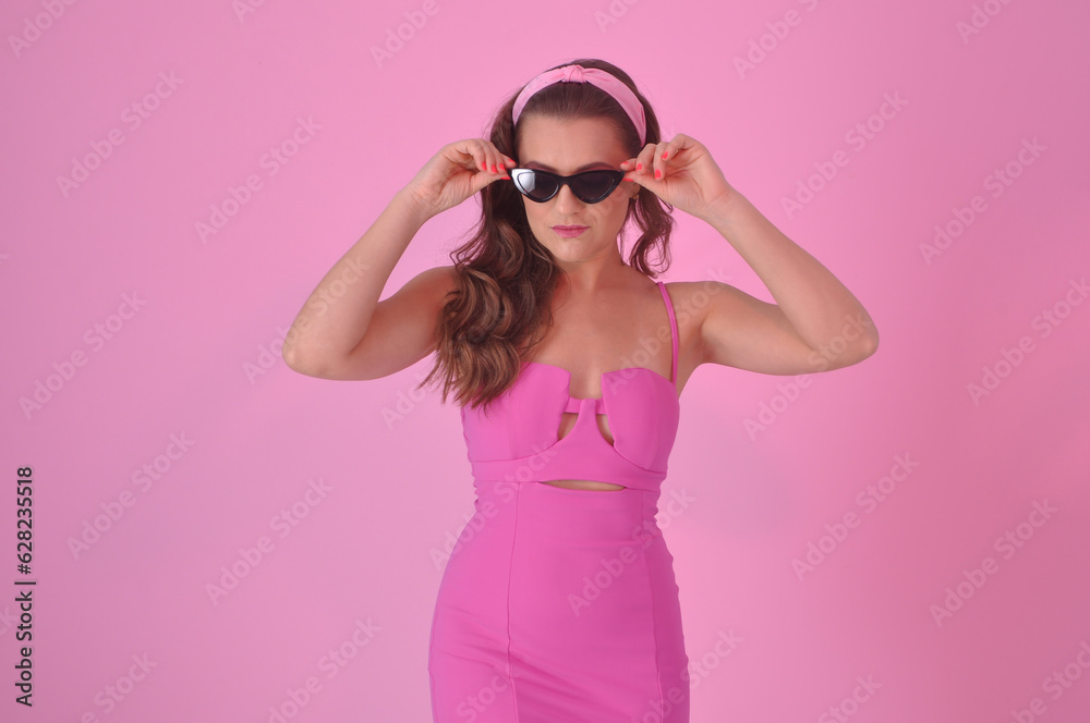 bela jovem estilo anos 60 retrô com laço no cabelo e óculos da época, vestido rosa em fundo rosa bela jovem estilo anos 60 retrô com laço no cabelo e óculos da época, vestido rosa em fundo rosa