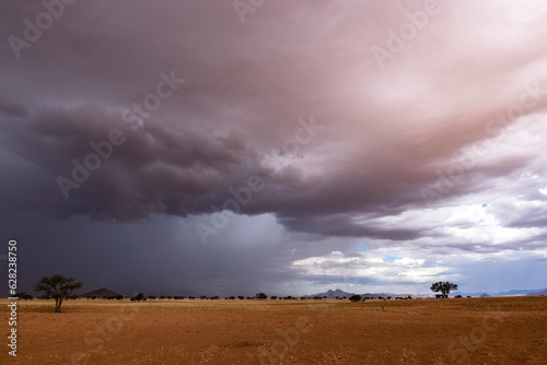 Dark blue clouds pour out rain on the dry desert