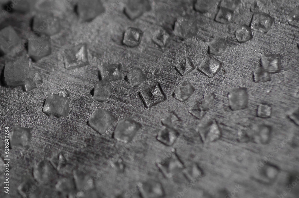macro of small salt crystals on a metal plate macro of small salt crystals on a metal plate