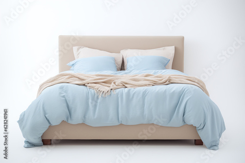 A bed with a quilt seen against a uniform light background