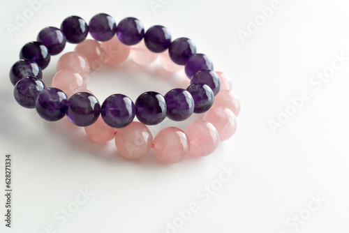 Rose quartz and amethyst bracelets on the table. 