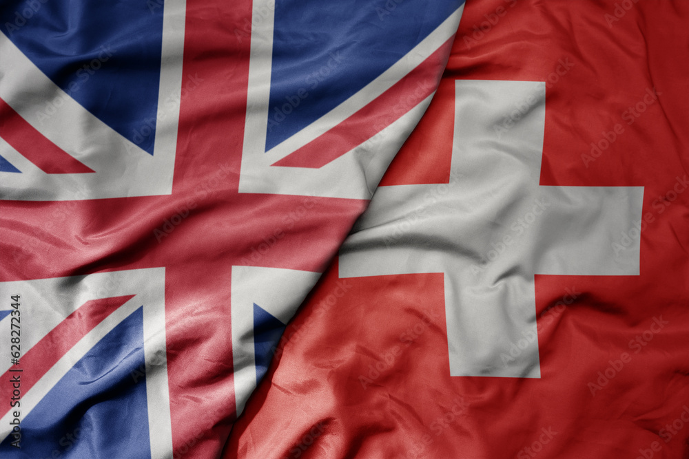 big waving national colorful flag of great britain and national flag of switzerland . big waving national colorful flag of great britain and national flag of switzerland .