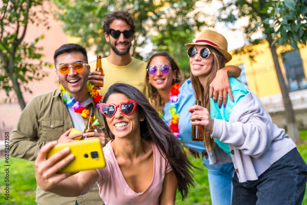 Multi ethnic group of friends partying in the city park taking a selfie, friendship and fun concept wearing sunglasses at a birthday party Multi ethnic group of friends partying in the city park taking a selfie, friendship and fun concept wearing sunglasses at a birthday party