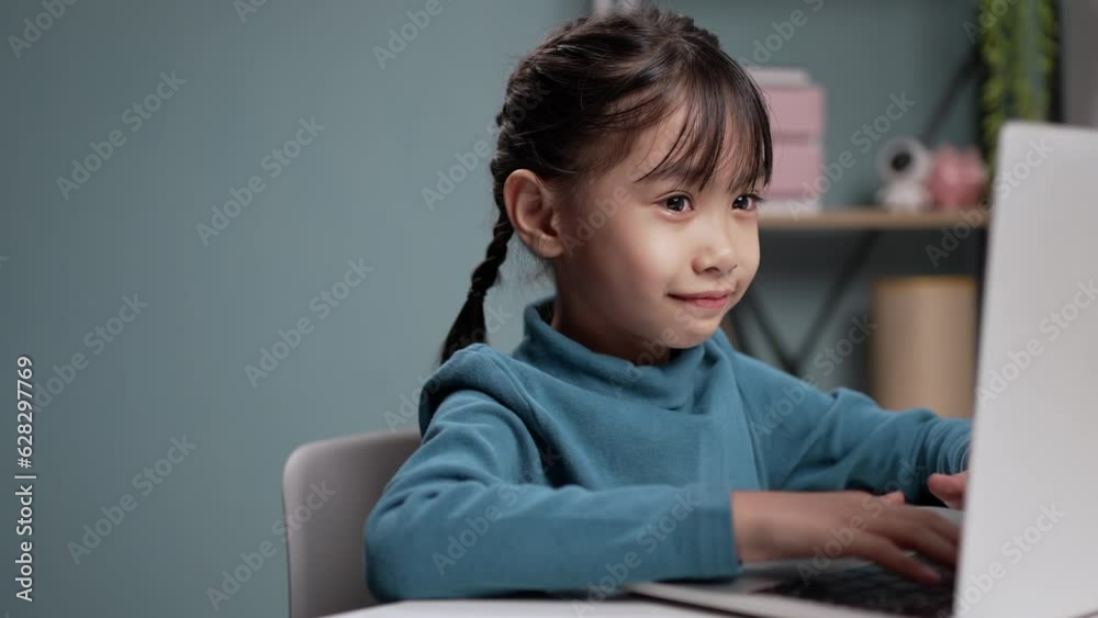 Little girl using a computer laptop for online education.