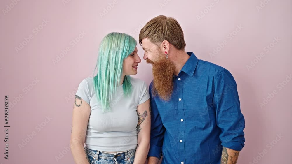 Man and woman couple smiling confident standing together kissing over isolated pink background Man and woman couple smiling confident standing together kissing over isolated pink background