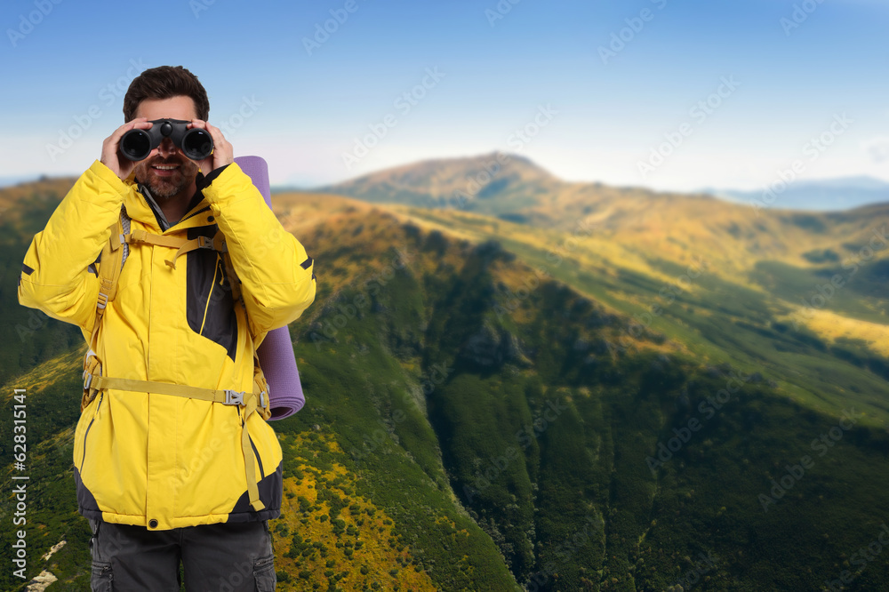 Tourist with backpack and binoculars in mountains