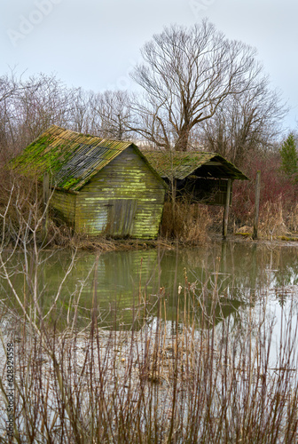 Dilapidated Sheds on the Shore of a Slough. Old sheds in Finn Slough on the banks of the Fraser River near Steveston in Richmond, British Columbia, Canada.   © maxdigi