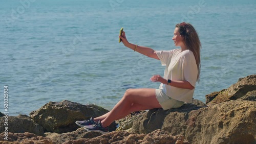 A woman sitting by the water on a rock in Terragona photo