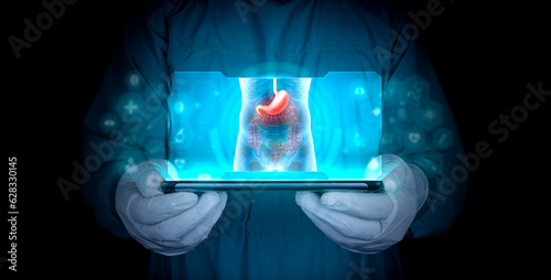 Stomach pain and epigastric abdominal pain. Symptoms of stomach acid reflux disease. Doctor projects on his tablet the stomach of the human body in x-rays photo