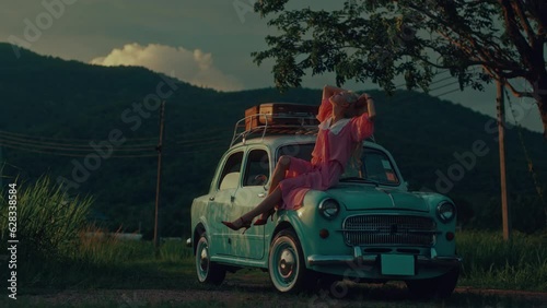 Wallpaper Mural Portrait of a girl in a pink vintage dress sitting on the hood of a turquoise-colored retro car Torontodigital.ca