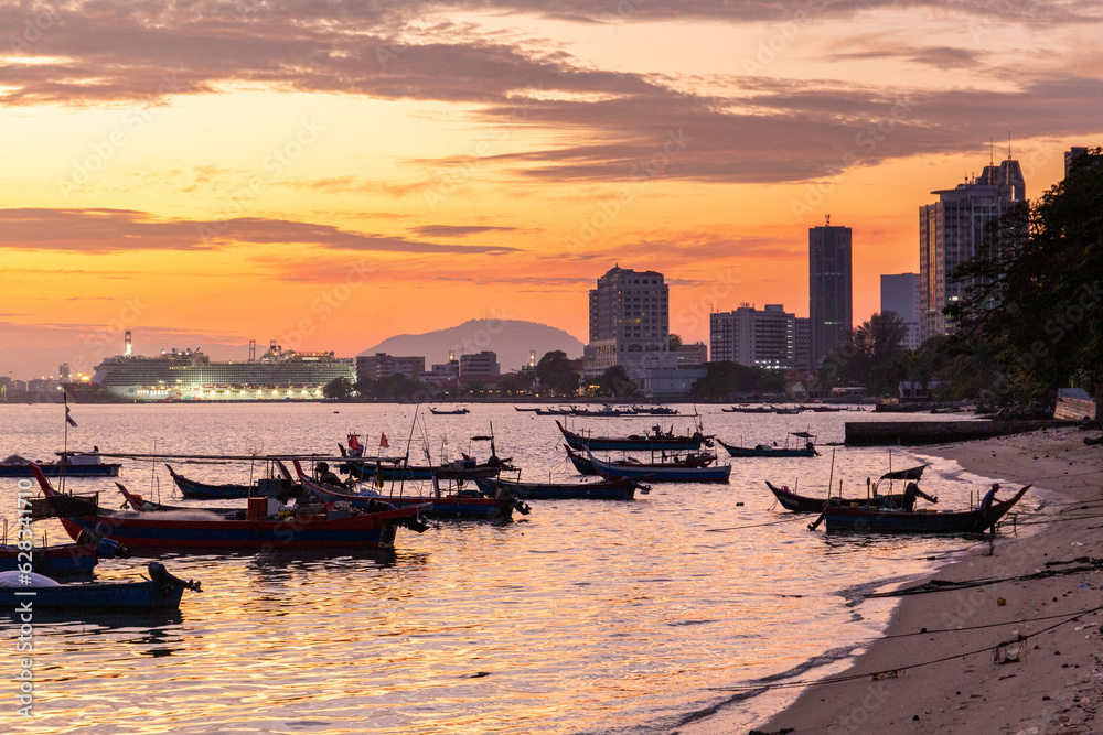 Fototapeta premium Colourful sunset sky over the sea with silhouette boat on the horizon. Tranquility scene. Abstract landscape background. Rural scene.