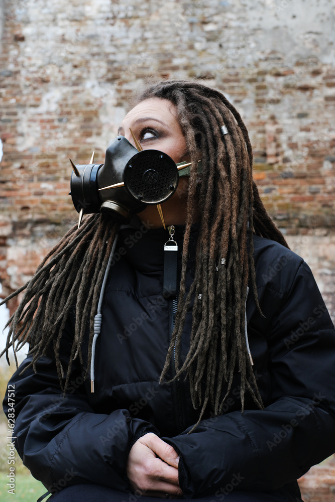 Obraz premium Woman wearing gas mask standing in ruined building