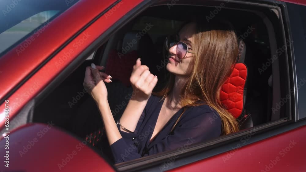Close-up of a beautiful girl sitting behind the wheel in a red car during the day in the light of the sun. Dancing and singing
Close-up of a beautiful girl sitting behind the wheel in a red car during the day in the light of the sun. Dancing and singing