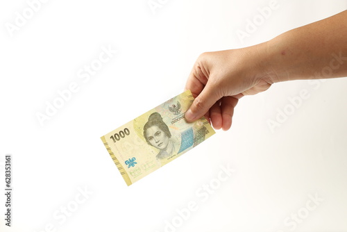 Hand holds Indonesian currency cash. Indonesian Money. IDR 1000.