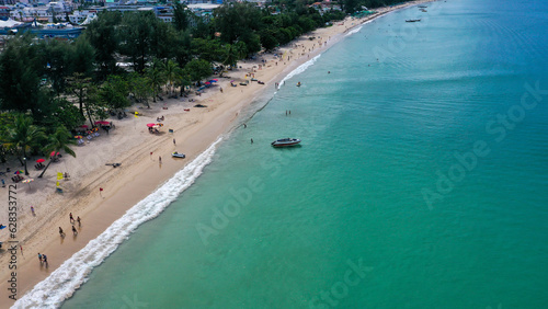 Aerial view of clear sea water with boats and tourists enjoying the beach in Patong beach, Phuket island, Thailand.