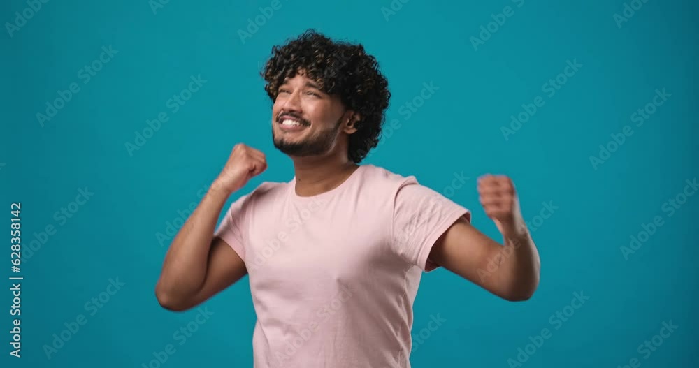 Young indian man fan watching tv and showing positive winning emotions about favourite team wins the game Young indian man fan watching tv and showing positive winning emotions about favourite team wins the game
