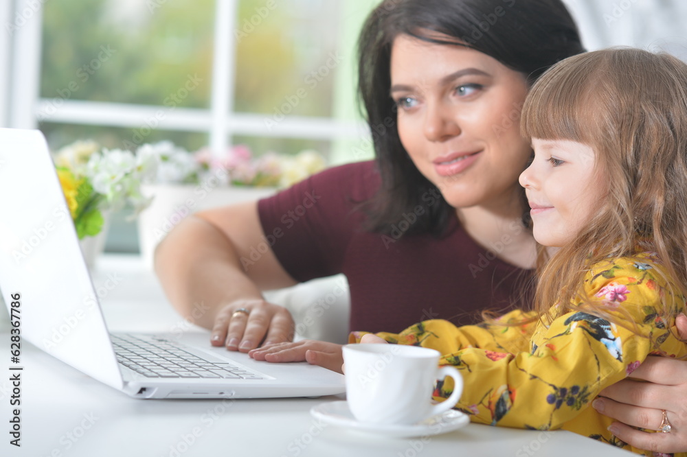 Mother and daughter doing homework on laptop Mother and daughter doing homework on laptop