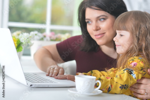 Mother and daughter doing homework on laptop