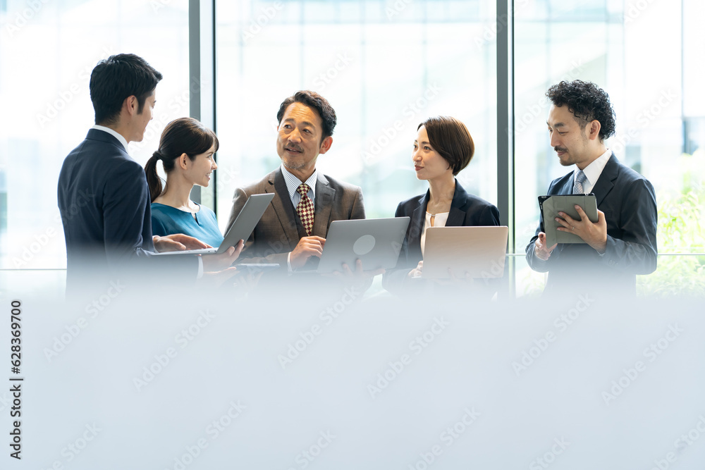立ちながら会議をするビジネスマン 立ちながら会議をするビジネスマン
