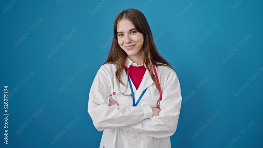 Young hispanic woman doctor smiling confident standing with arms crossed gesture over isolated blue background Young hispanic woman doctor smiling confident standing with arms crossed gesture over isolated blue background