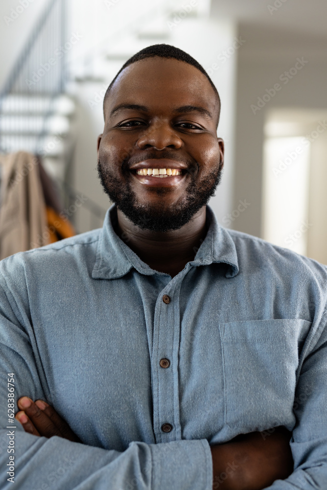 Portrait of happy african american man with short hair and arms crossed at home Portrait of happy african american man with short hair and arms crossed at home