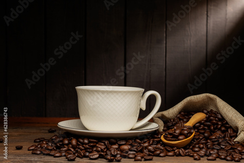 white coffee cup with black coffee or hot tea in a cappuccino espresso cup Breakfast with coffee beans on wooden table isolated on black background