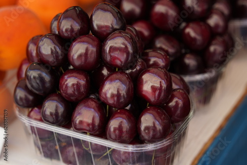 Black cherries standing in a plastic box on the market