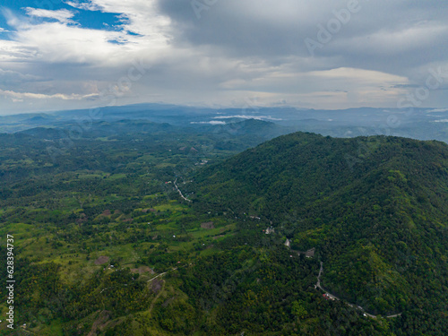 Fototapeta Naklejka Na Ścianę i Meble -  Mountain with jungle and agricultural land. Blue sky and clouds. Mindanao, Philippines.