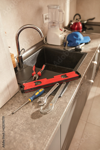 Plumber tools for fixing and repairing water tap on the kitchen sink.