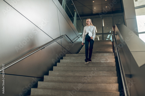 Slim elegant woman on the stairs in the office center