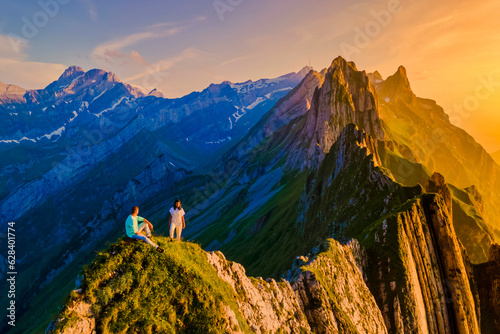 Schaeffler mountain ridge swiss Alpstein, Appenzell Switzerland, ridge of the majestic Schaeffler peak by Berggasthaus Schafler, Switzerland. couple man and women in the mountains during sunset photo