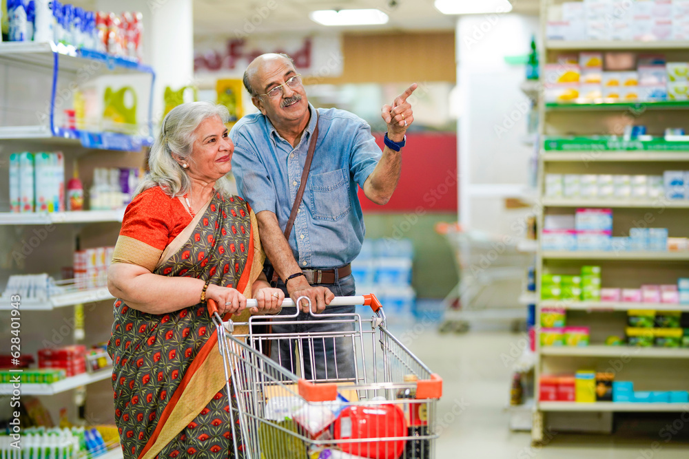 Senior indian couple purchasing together at super market.