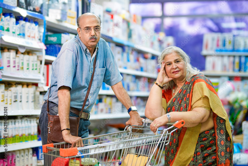 Senior indian couple purchasing together at super market.