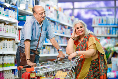 Senior indian couple giving expression while shopping at super market.