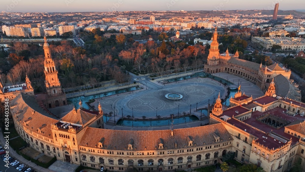 Fototapeta premium Flying around Plaza de Espana - Spanish Square - in Sevilla, Spain. Aerial tele shot of Plaza de Espana complex in morning sun lights