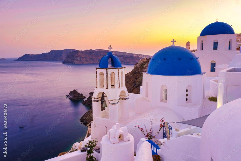 Naklejka premium White churches an blue domes by the ocean of Oia Santorini Greece, a traditional Greek village in Santorini.