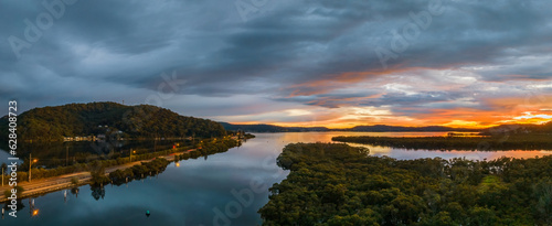 A moody winter sunrise panorama waterscape with clouds