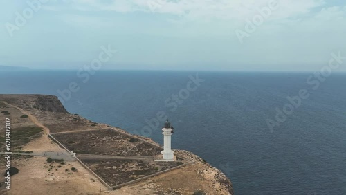 Reverse reveal from Es Cap de Barbaria lighthouse of the Mediterranean sea photo