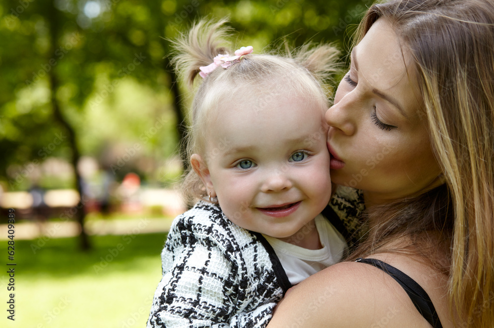 Mother and daughter walk in the summer city park. Childhood, leisure and people concept - happy family rest on nature and have a good time Mother and daughter walk in the summer city park. Childhood, leisure and people concept - happy family rest on nature and have a good time
