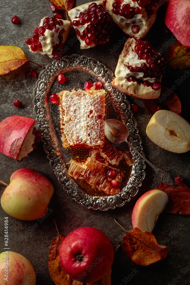 Honeycomb, apples, and pomegranate on an old stone table. Honeycomb, apples, and pomegranate on an old stone table.