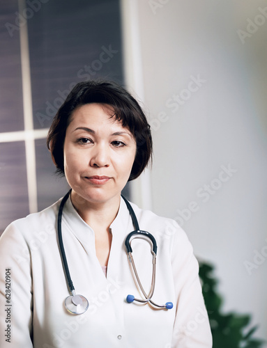 immagine primo piano di donna medico, infermiera , mezza età, sguardo attento, professionalità e competenza, ambiente di lavoro sfuocato photo