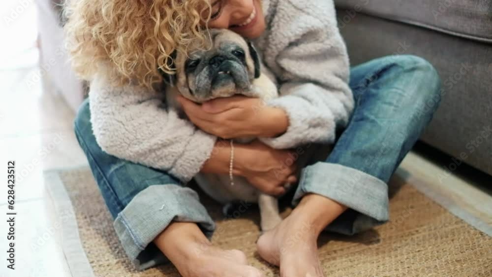One female owner bonding her old pug dog at home sitting on the floor. Concept of love and affection for animals. Domestic lifestyle with puppy. Together best friend aged pet. One woman and dog One female owner bonding her old pug dog at home sitting on the floor. Concept of love and affection for animals. Domestic lifestyle with puppy. Together best friend aged pet. One woman and dog