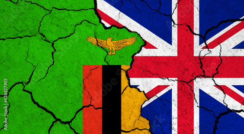 Flags of Zambia and United Kingdom on cracked surface - politics, relationship concept