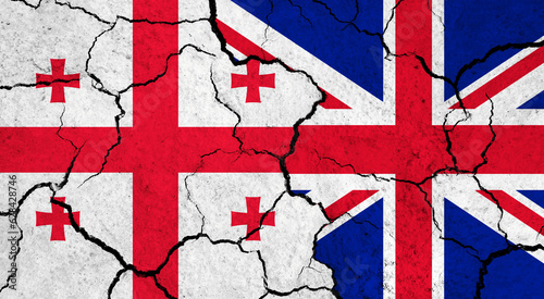 Flags of Georgia and United Kingdom on cracked surface - politics, relationship concept
