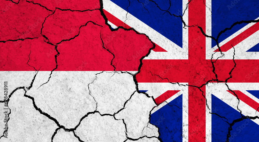 Fototapeta premium Flags of Indonesia and United Kingdom on cracked surface - politics, relationship concept