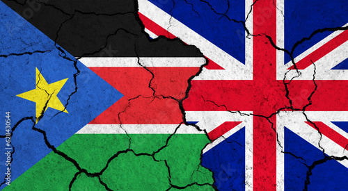 Flags of South Sudan and United Kingdom on cracked surface - politics, relationship concept